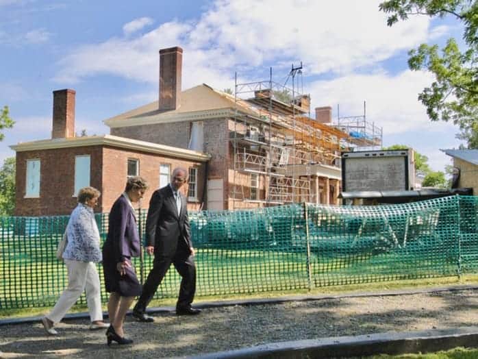 Lou Potter, Cokie Roberts, and Michael Quinn walking beside the back of the mansion.