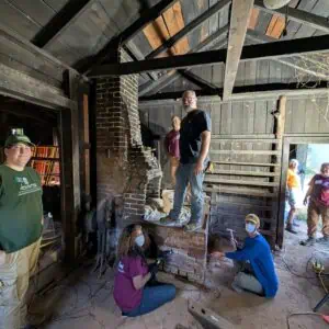 Participants repairing masonry joints at mid 19th century blacksmith forge at Montpelier.