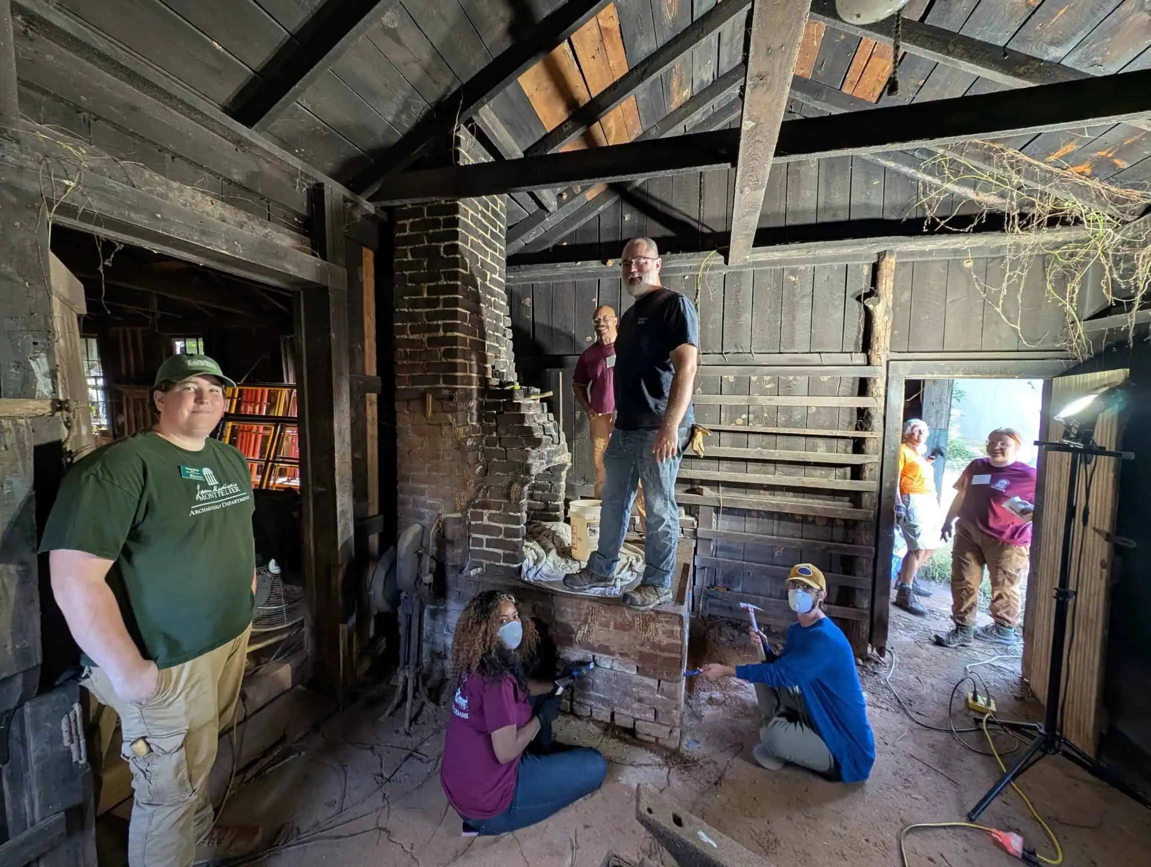 Participants repairing masonry joints at mid 19th century blacksmith forge at Montpelier.