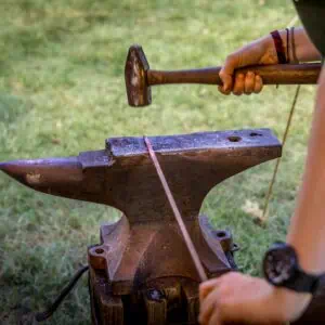 Participant hammering nail stock to a point for the creation of a wrought nail. Participants will learn a range of metal working under the direction of heritage blacksmiths.Photograph by Gene Runion
