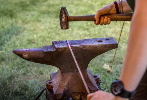 Participant hammering nail stock to a point for the creation of a wrought nail. Participants will learn a range of metal working under the direction of heritage blacksmiths.Photograph by Gene Runion