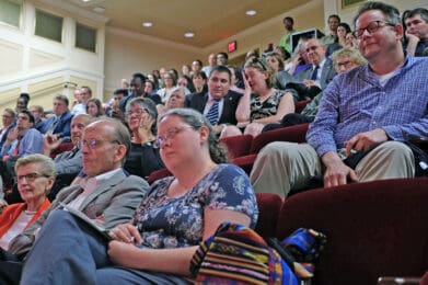 Audience seated in a lecture hall, attentively listening to a presentation or speaker.